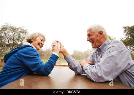 Husband and wife arm wrestling in the park Stock Photo