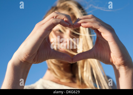 Young woman making heart sign with hands, Breezy Point, Queens, New York, USA Stock Photo