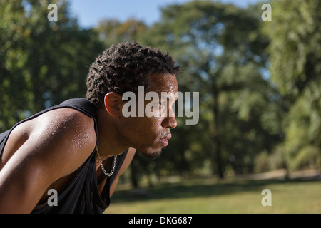 Portrait of young man wearing black vest, side view Stock Photo
