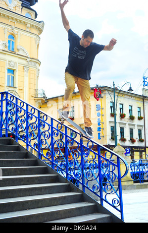 Teenager skateboarder is practicing and performing jump tricks on stairs in Krakow, Poland. Stock Photo