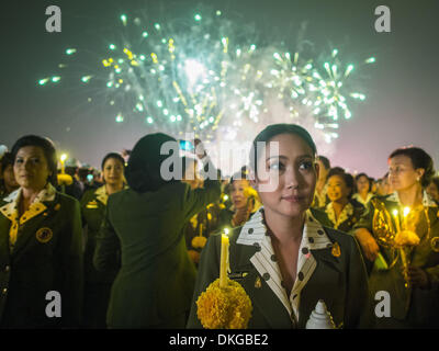 Bangkok, Thailand. 5th Dec, 2013. Fireworks go off while Thais hold candles to honor the King. Thais observed the 86th birthday of their revered king of Thailand, King Bhumibol Adulyadej. Candlelight services were held throughout the country. The political protests that have gripped Bangkok were on hold for the day, with protestors holding their own observances of the holiday. Thousands of people attended the government celebration of the day on Sanam Luang, the large public space next to the Grand Palace. Credit:  Jack Kurtz/ZUMAPRESS.com/Alamy Live News Stock Photo