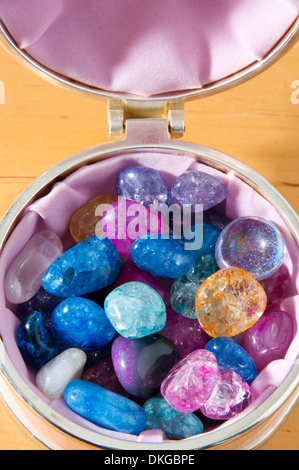 jewellery box containing different coloured stones on a wooden table Stock Photo