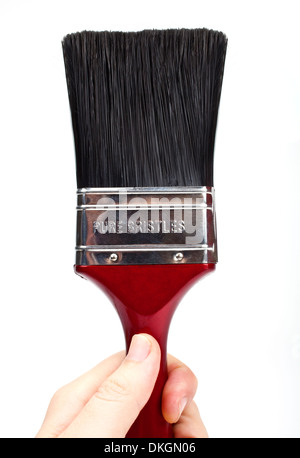Hand holding a paint brush over a white background. Stock Photo