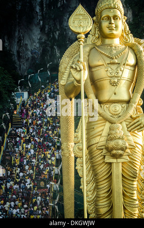 Devotees climb to Batu Caves, overseen by a statue of Lord Murugan during Thaipusam, Batu Caves, Kuala Lumpur, Malaysia. Stock Photo