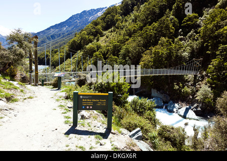 A hiking trail crosses a river by suspension bridge on the South Island of New Zealand Stock Photo