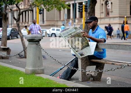 Pretoria, South Africa. 6th December 2013. A man reading of Madiba's death at Church Square, on December 6, 2013 in Pretoria, South Africa. The Father of the Nation, Nelson Mandela, Tata Madiba, passed away quietly on the evening of December 5, 2013 at his home in Houghton with family. (Photo by Gallo Images / Foto24 / Herman Verwey) Credit:  Gallo images/Alamy Live News Stock Photo