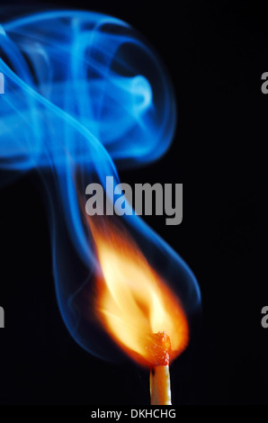 lighting a match on black background Stock Photo