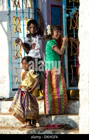 Rural indian children playing on village temple steps in the sunlight. Andhra Pradesh, India Stock Photo