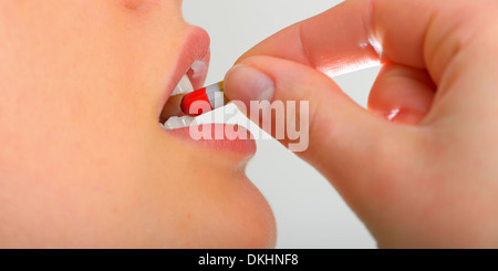 young woman taking pill close up Stock Photo