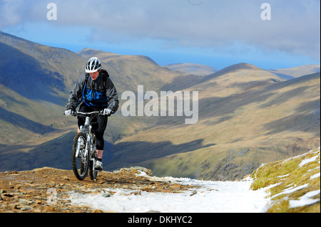 A mountain biker rides up the Llanberis Path to the summit of Mount Snowdon in Snowdonia National Park. Stock Photo