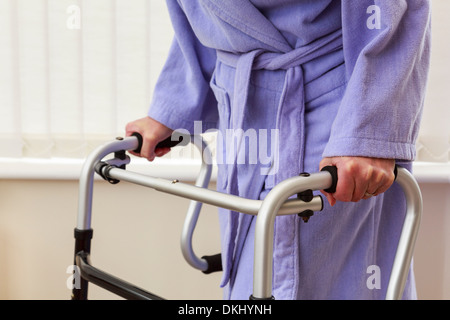 Elderly senior woman older person hand holding using a zimmer frame walker or support trolley for walking in a home. England UK Britain Stock Photo
