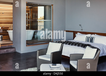 Bed and armchairs in modern bedroom Stock Photo