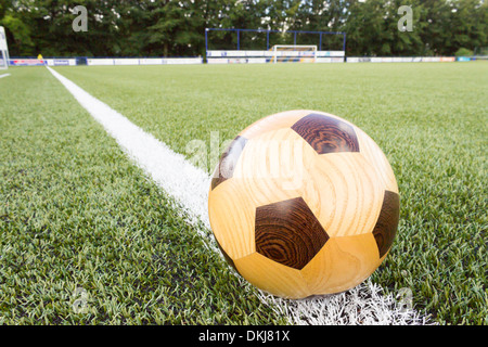 Wooden football lying on sideline of a football field Stock Photo