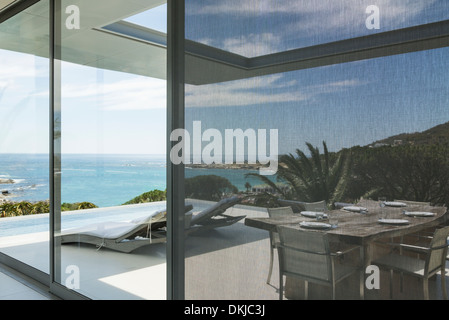 View of ocean beyond patio and swimming pool Stock Photo