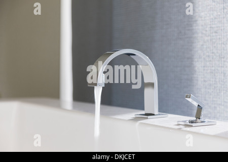 Water emitting from modern faucet Stock Photo