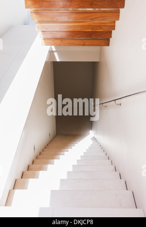 Light shining down staircase in modern house Stock Photo