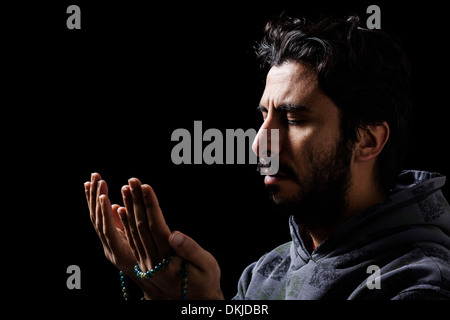 Western Muslim Praying with Tasbih Stock Photo