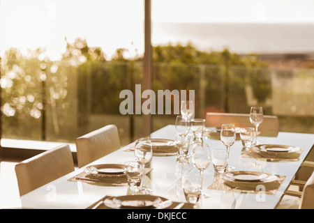 Set table in modern dining room Stock Photo