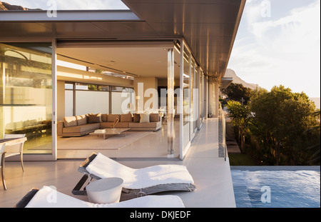 Lounge chairs at poolside of modern house Stock Photo