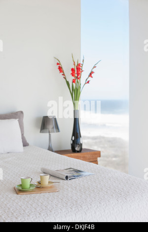 Breakfast tray on bed in modern bedroom with ocean view Stock Photo