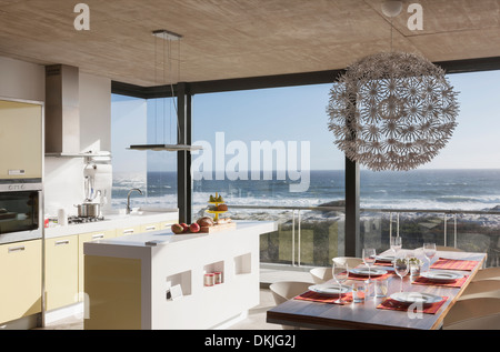 Kitchen and dining room in modern house overlooking ocean Stock Photo