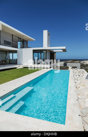 Lap pool and lawn outside modern house Stock Photo