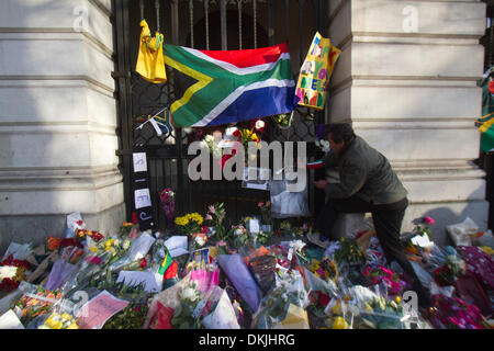 London UK. 6th December  2013. A man places a portrait of Nelson Mandela  outside the South Africa House  who died yesterday aged 95. Nelson Mandela became the first black president who was jailed after he campaigned against Apartheid and a racially divided South Africa Credit:  amer ghazzal/Alamy Live News Stock Photo
