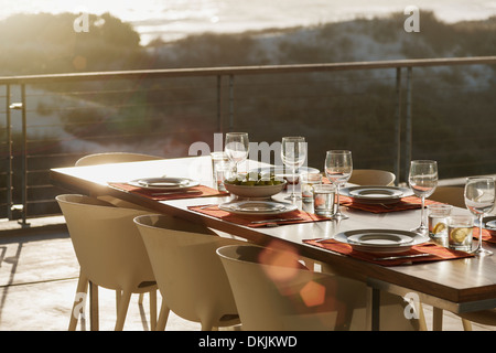 Set table in modern dining room open to balcony Stock Photo