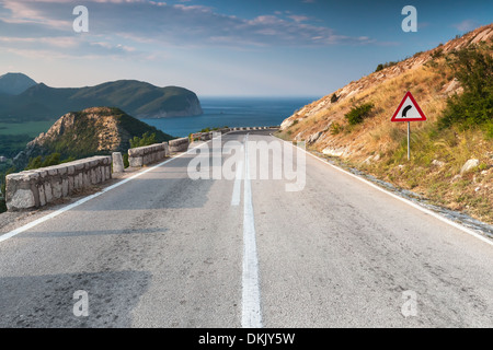 Dividing line and right turn sign on the coastal mountain highway. Montenegro Stock Photo
