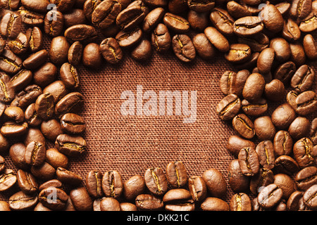 Spilled coffee beans frame over linen textile Stock Photo