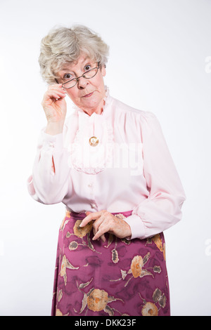 Stern elderly woman peering over glasses Stock Photo