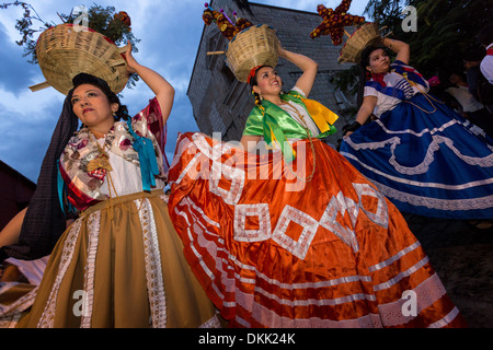 Young women dressed in traditional costumes parade in a comparsas past the Santo Domingo de Guzmán Church during the Day of the Dead Festival known in Spanish as Día de Muertos on November 2, 2013 in Oaxaca, Mexico. Stock Photo