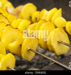 Roasted potato on the skewers with lard pieces Stock Photo