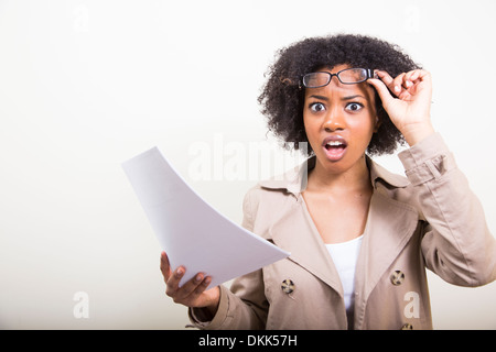 African American woman holding papers looking shocked Stock Photo