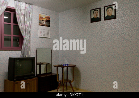 Mock-up of North Korean family home interior displaying portraits of Kim Il Sung and Kim Jong Il on wall Stock Photo