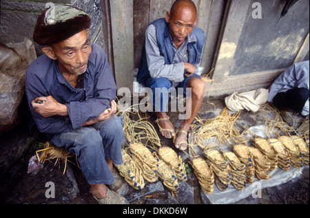 Two men selling straw shoes in a market in Hunan Province, China Stock Photo