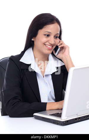Happy young business woman talking on mobile phone against white Stock Photo