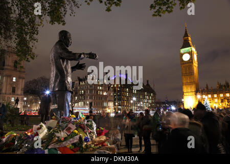 London, UK. 06th Dec, 2013. Mourners gather to lay flowers and light candles at the foot of the Nelson Mandela Statue in Parliament Square. Central London 6th December 2013  Credit:  Zute Lightfoot/Alamy Live News Stock Photo