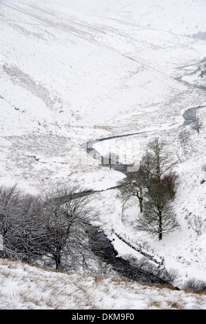A river meanders through a valley in snow near Simonsbath on Exmoor in winter, UK Stock Photo