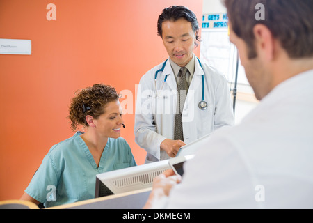Medical Team Using Digital Tablet While Patient Standing At Rece Stock Photo