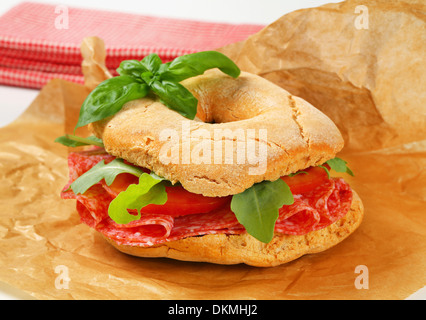 Italian bread roll with thin slices of dry salami Stock Photo