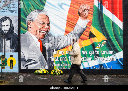 Belfast, Northern Ireland. 7th Dec 2013 - A man looks at floral tributes left at Mandela Mural following the death of Nelson Mandela on the 5th December. Credit:  Stephen Barnes/Alamy Live News
