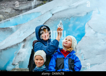 Mother with piece of ice in hand and two children near Nigardsbreen glacier (Norway) Stock Photo