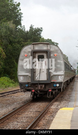 The back of the train with a red carriage at the end of the road ...