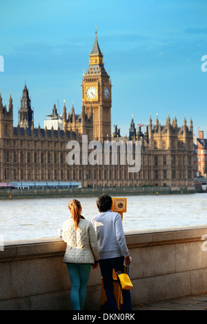 Young couple watching Big Ben at Thames riverside in London. Stock Photo