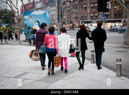 Young people in front of Plaza 66 commercial and office complex at West Nanjing Road - famous shopping street in Shanghai, China Stock Photo