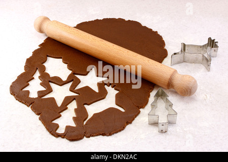 Rolling pin and festive cookie cutters with gingerbread dough - reindeer, Christmas tree, star and holly leaf Stock Photo