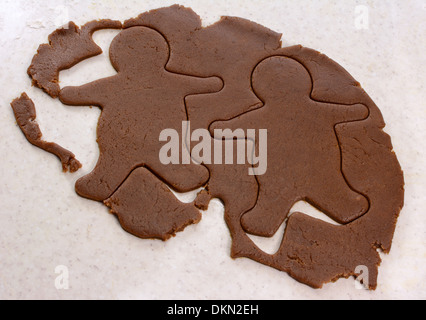 Two gingerbread men shapes cut into cookie dough Stock Photo