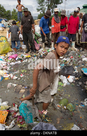 A child scavenging for anything of value within the Inayawan Landfill waste site,Cebu City,Philippines Stock Photo