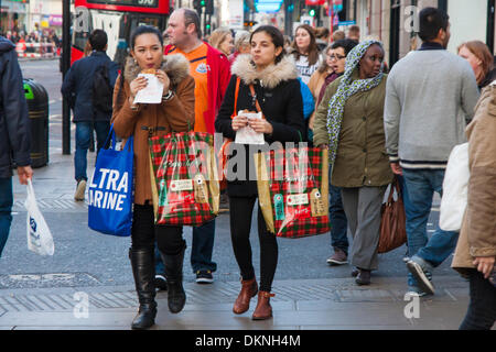 London, UK. 8th Dec 2013. Thousands of shoppers laden with bags throng London's Oxford Street as retailers mark down prices in a bid to increase sales ahead of Christmas. Credit:  Paul Davey/Alamy Live News Stock Photo